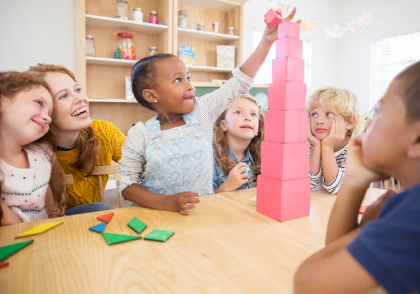Young female early learning teacher with group of children