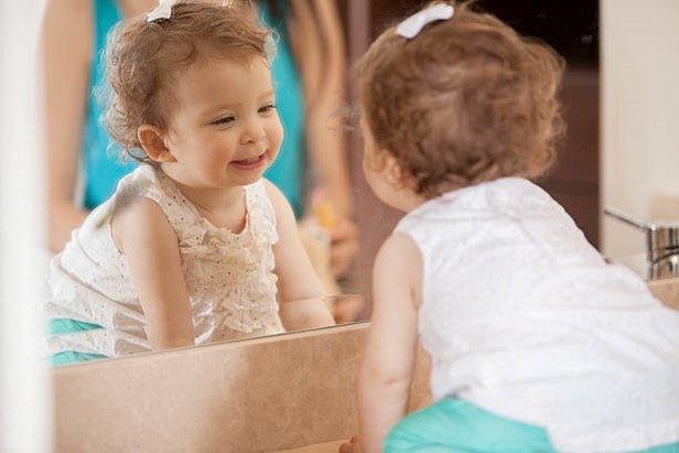 toddler smiling in mirror